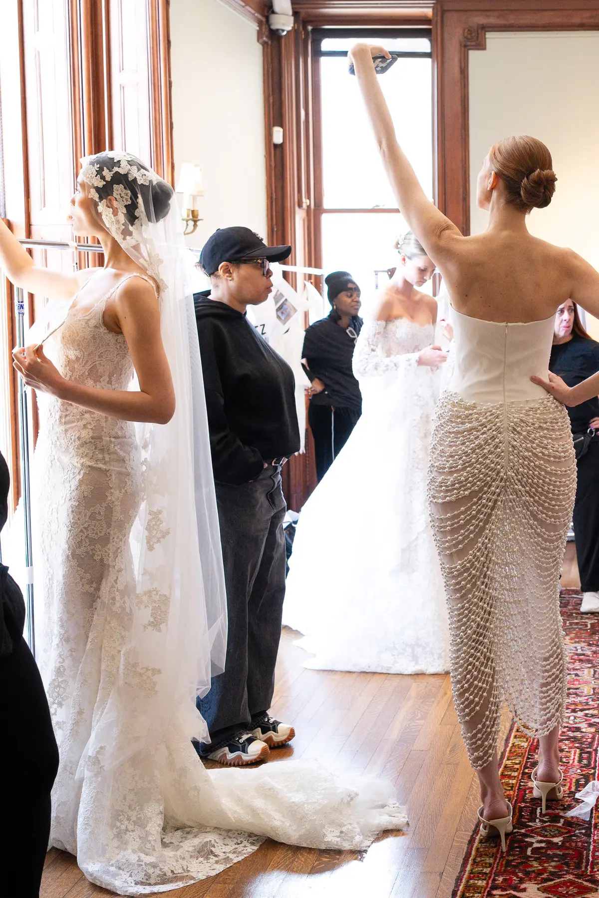 Behind the scenes at the Salon Privé runway show — a Lee Petra Grebenau bride having her gown adjusted