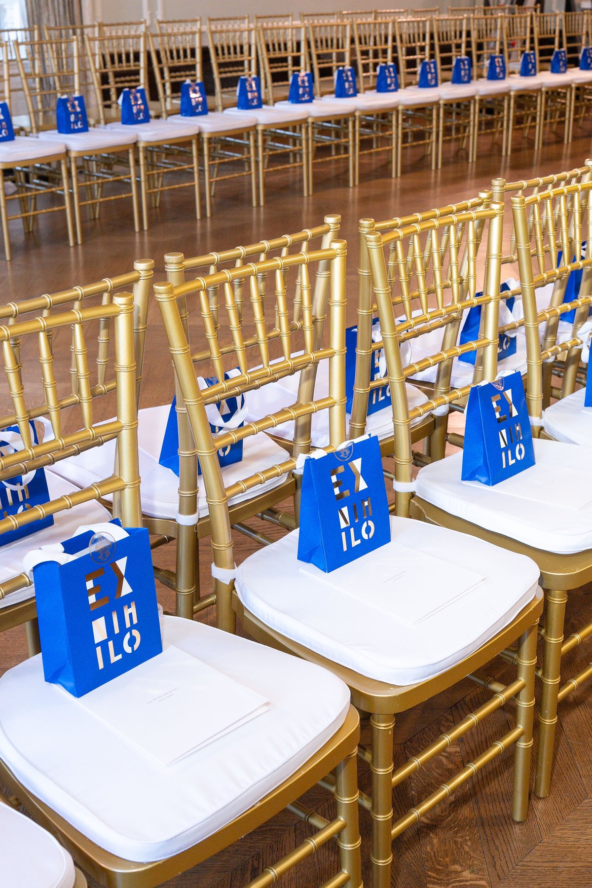 Gold chiavari chairs with white cushions and blue Ex Nihilo gift bags at the Lee Petra Grebenau Salon Privé runway show
