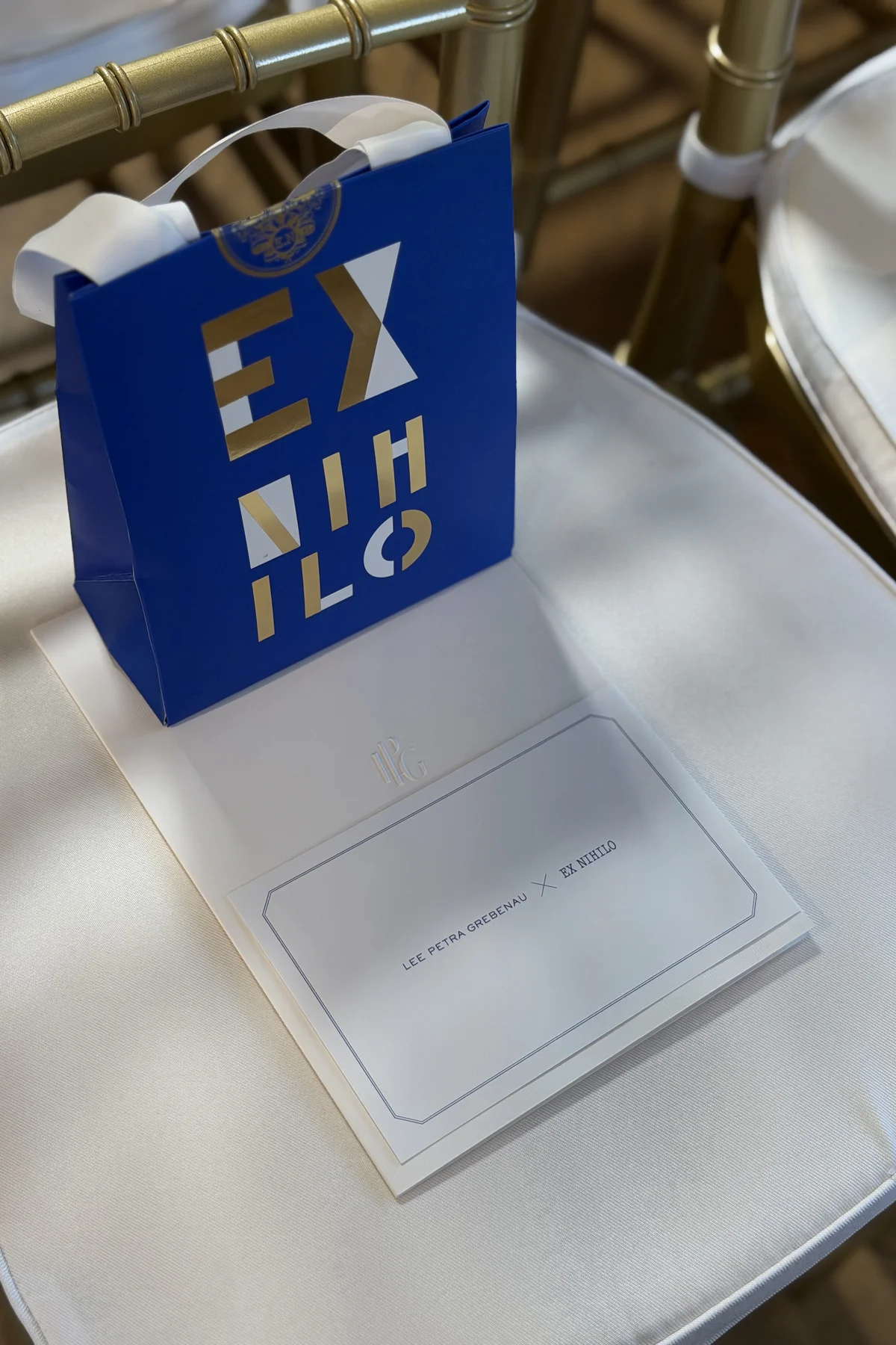 Lee Petra Grebenau x Ex Nihilo collaboration — gift bag and booklet on a chair at the event