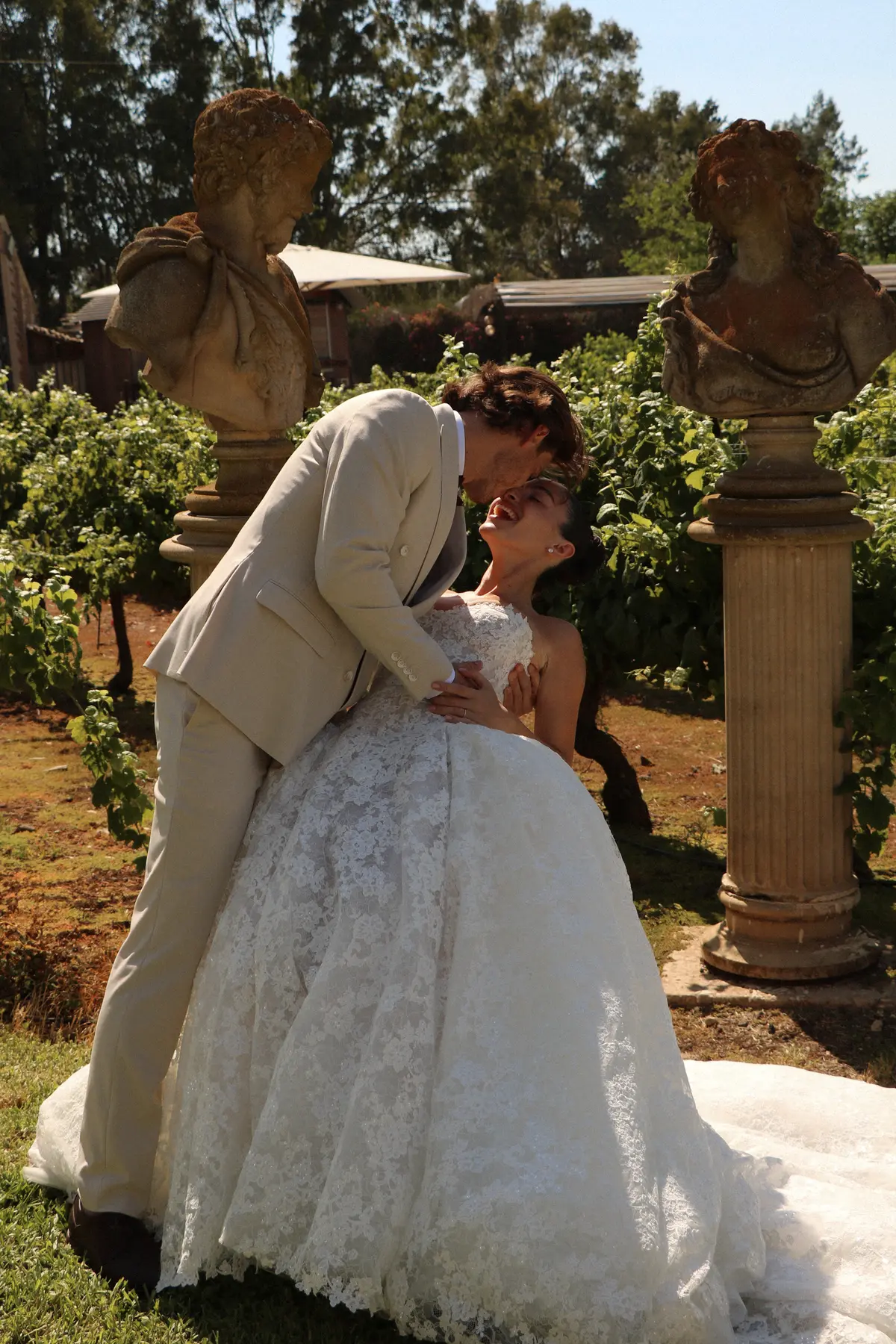 Bride and groom embracing in the garden — Lee Petra Grebenau Talisman lace ball gown