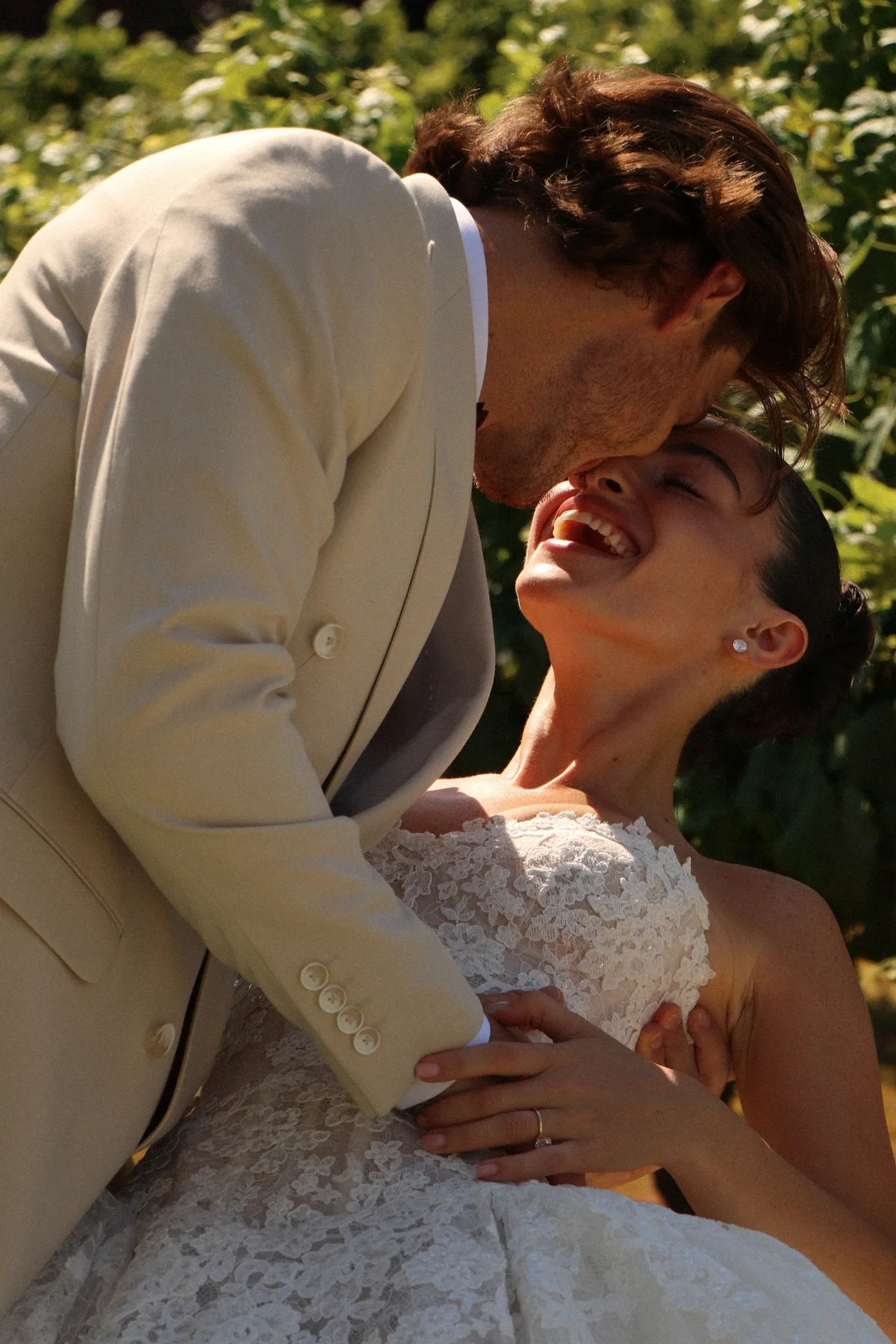 Groom kissing the laughing bride — Lee Petra Grebenau Talisman lace gown