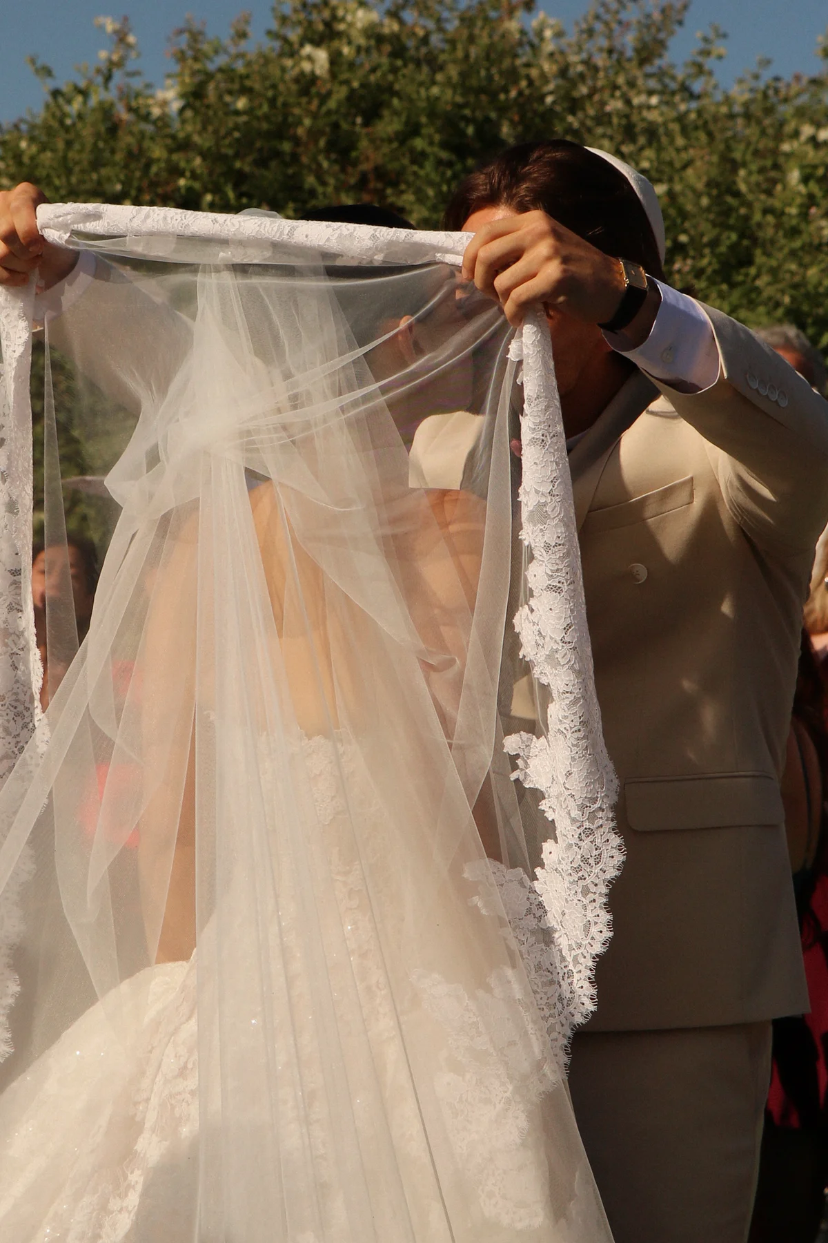 Groom lifting the bride's veil in the garden — Lee Petra Grebenau Talisman gown