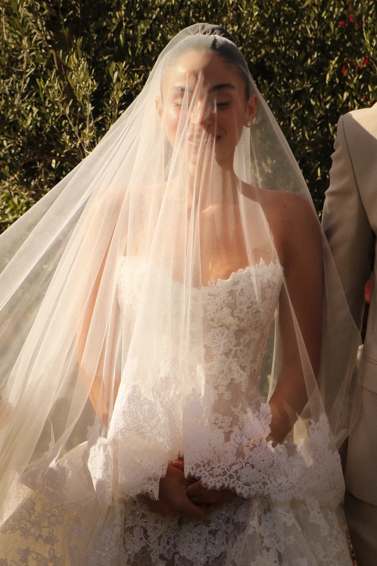 Bride in veil and the Talisman gown beside the groom — Lee Petra Grebenau lace ball gown