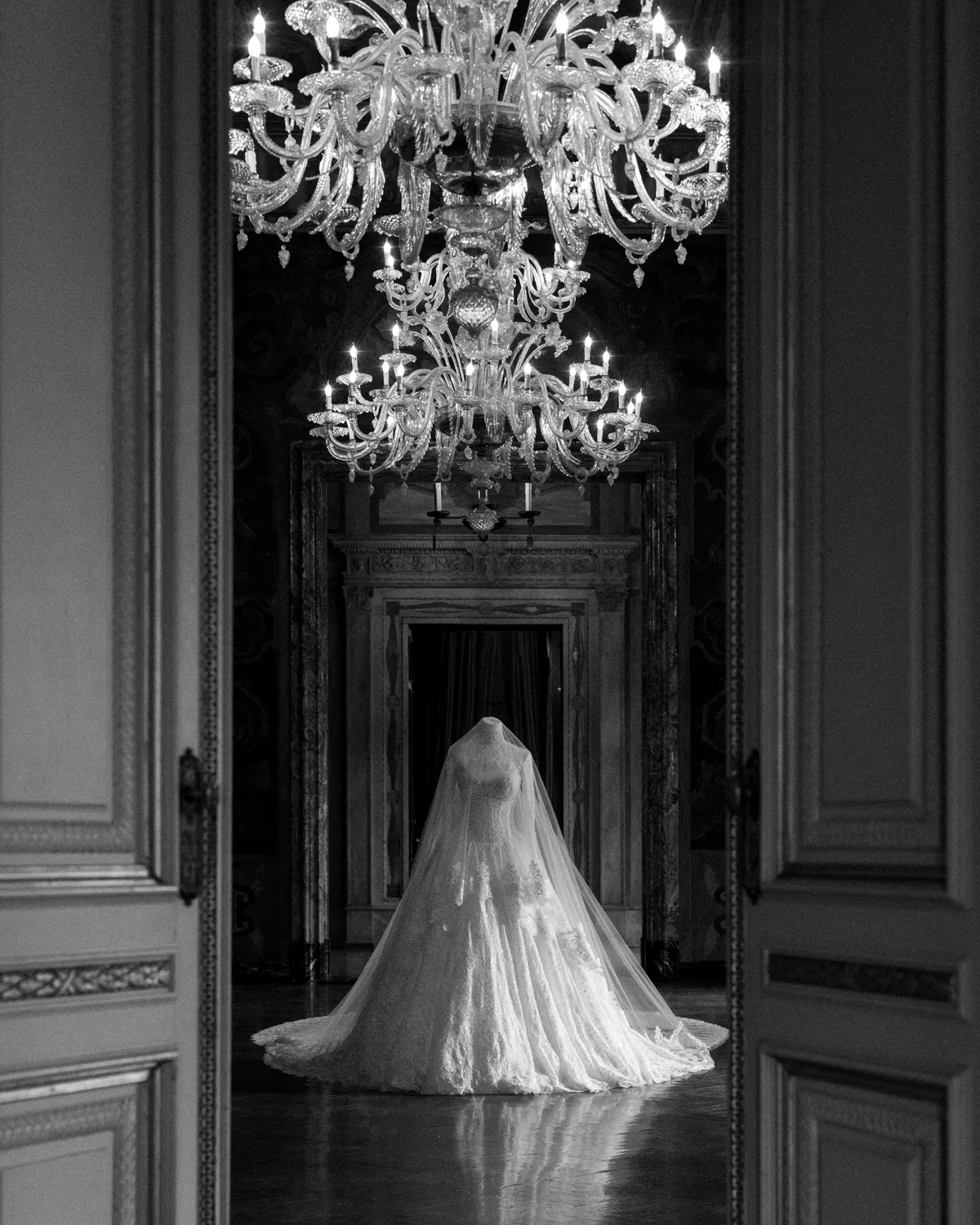 Bride with a long train beneath a crystal chandelier at Villa Erba — Lee Petra Grebenau Versailles gown