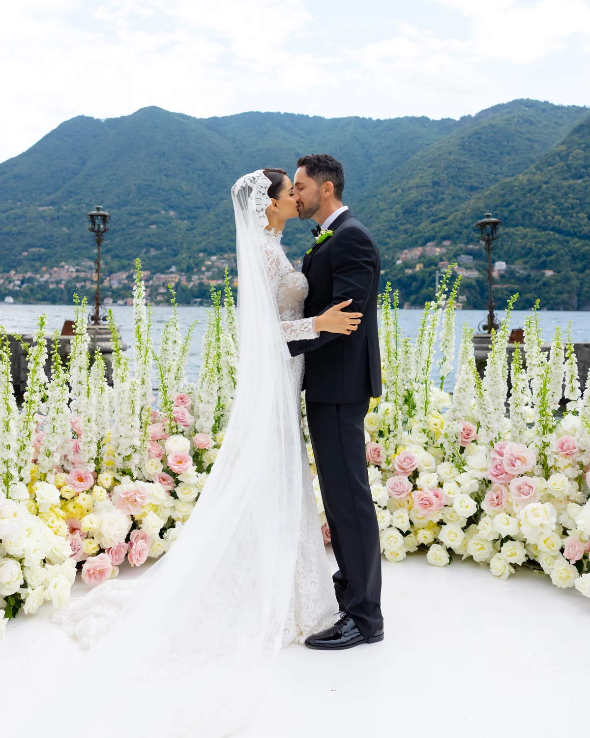 Bride and groom sharing a kiss among the florals at Lake Como — Lee Petra Grebenau Versailles gown