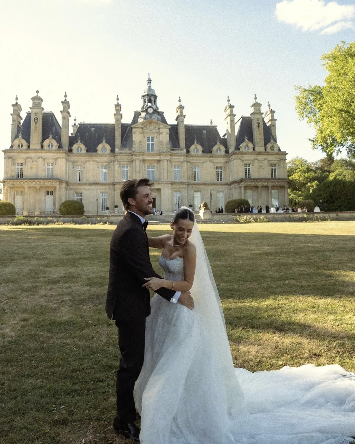 Danielle and Spencer embracing on the château lawn