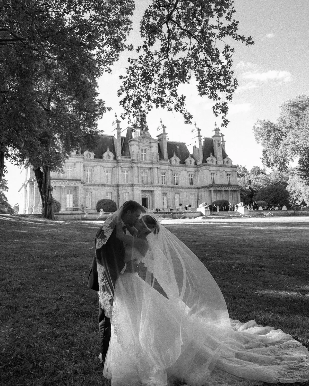 Danielle beneath the trees on the château grounds, her veil spread behind her