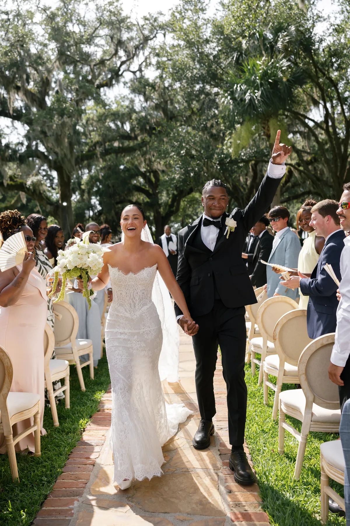Madison and Jaylin walking back up the aisle as their guests celebrate