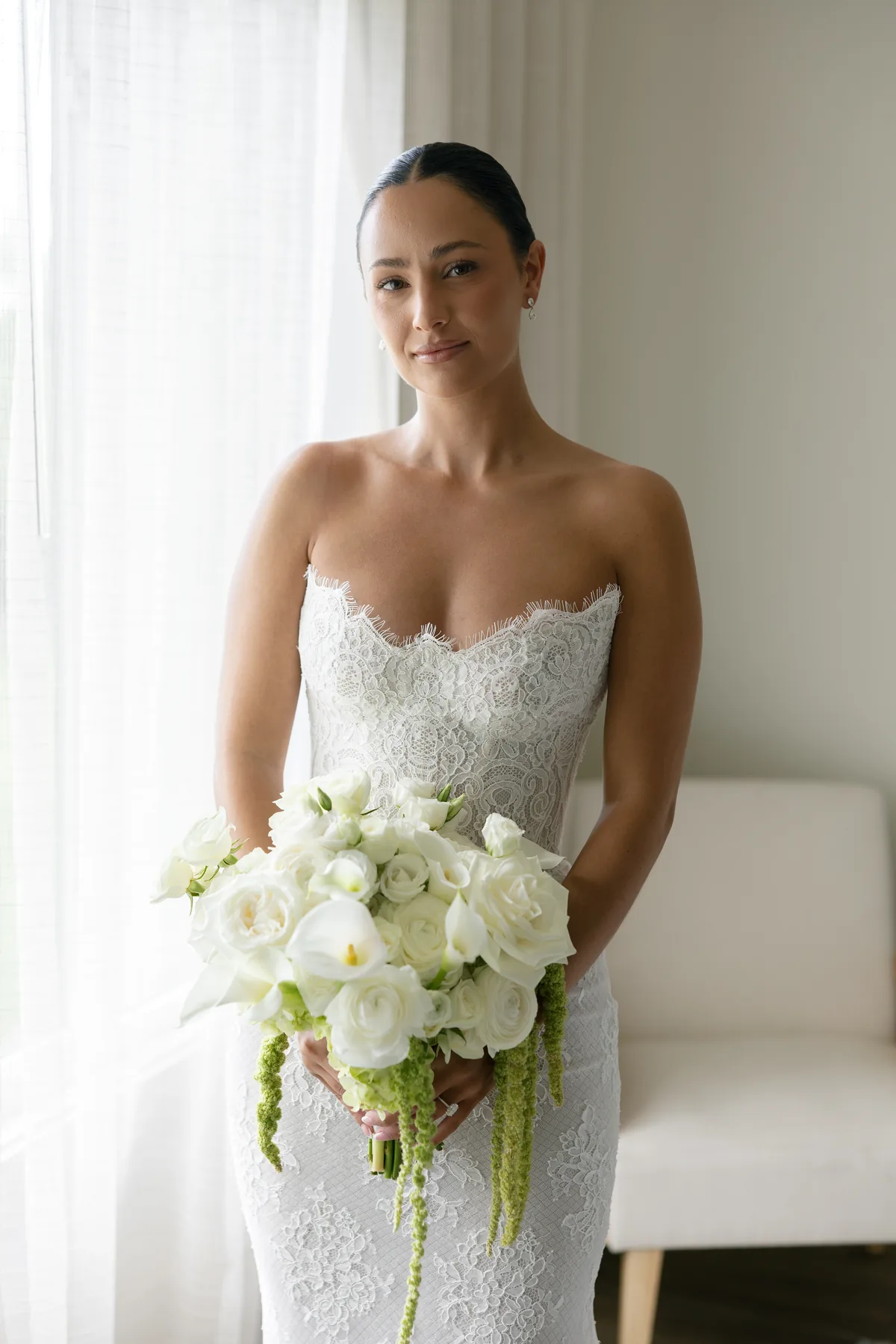 Madison holding her white bouquet, the strapless Tosca bodice in soft window light
